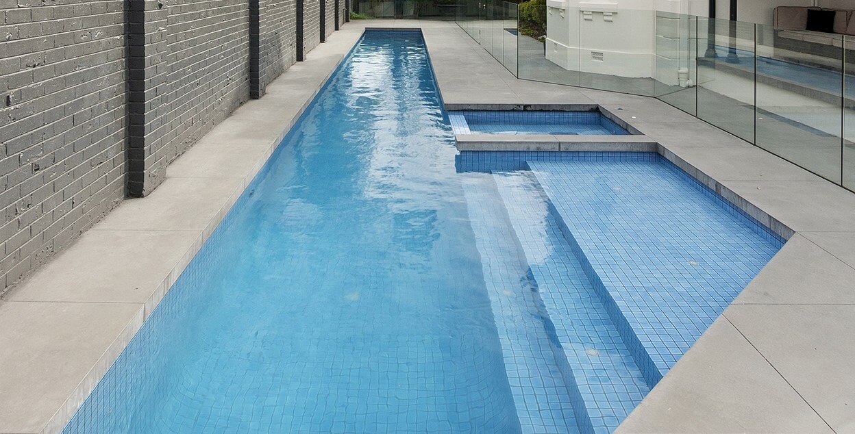 Concrete lap pool with a spa attached by Natural Pools